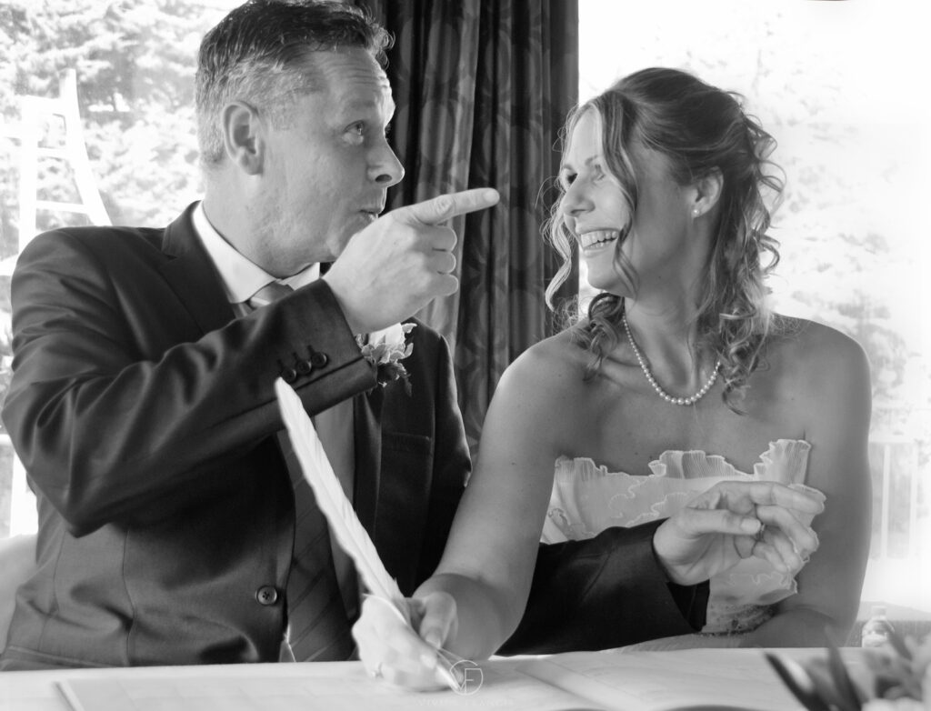Black and white coloured couple signing with a feather and smiling at each other