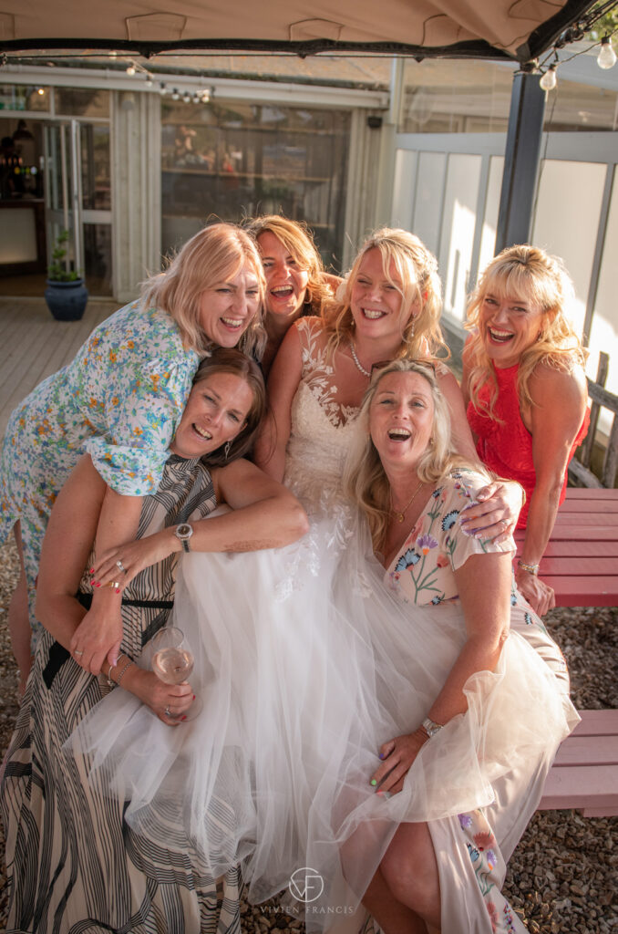 Group of women with bride in the middle all hugging and smiling